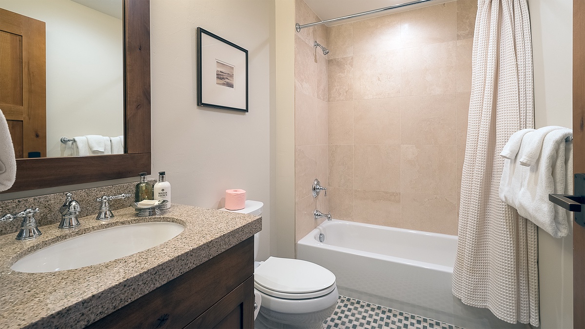 Shared Bathroom, Main Level - Hall bathroom adjacent to Bedroom 4 with single vanity and shower/tub combo