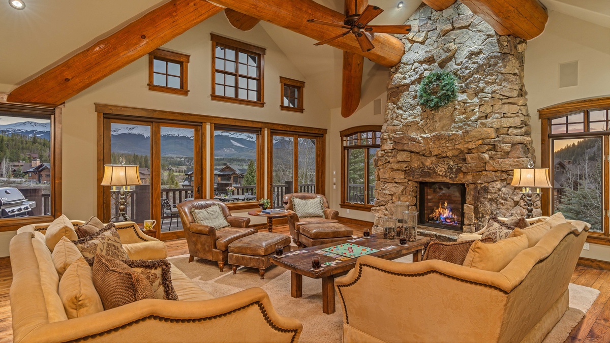 Main level great room with stone fireplace and mountain views