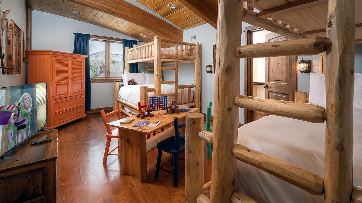Rustic log bunk beds and mountain views create a cozy retreat where your family can make lasting memories after adventurous days exploring the slopes.