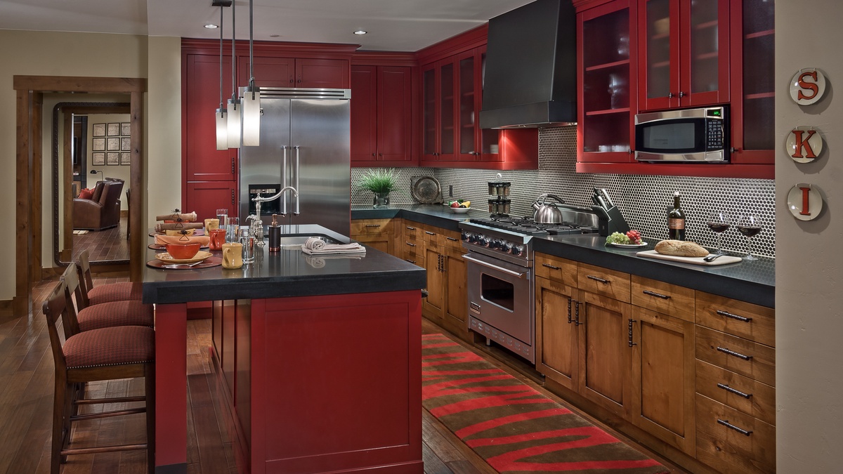 Kitchen, Main Level - With stainless steel appliances and bold red cabinetry