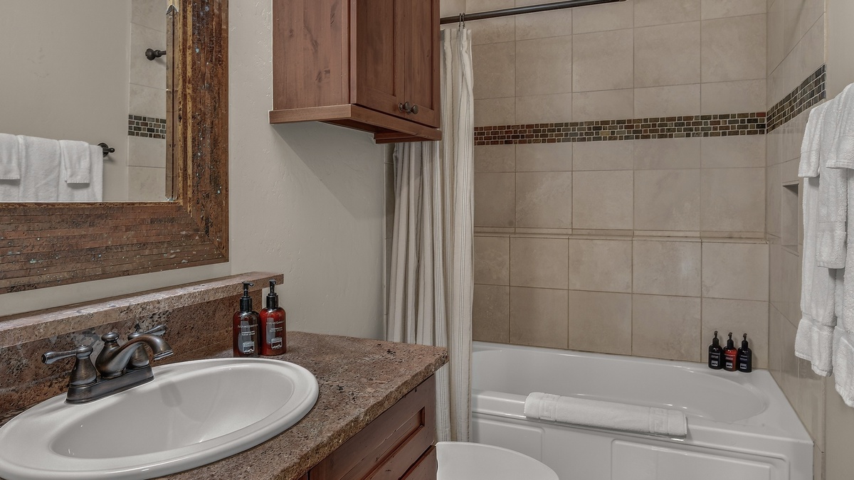 Shared Bathroom, Lower Level - Hall bathroom adjacent to Bedroom 2 with single vanity and shower/tub combo