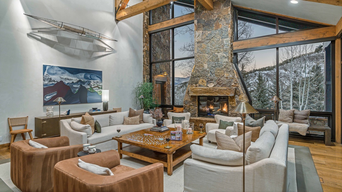 Main level great room with stone fireplace, high ceilings, and views