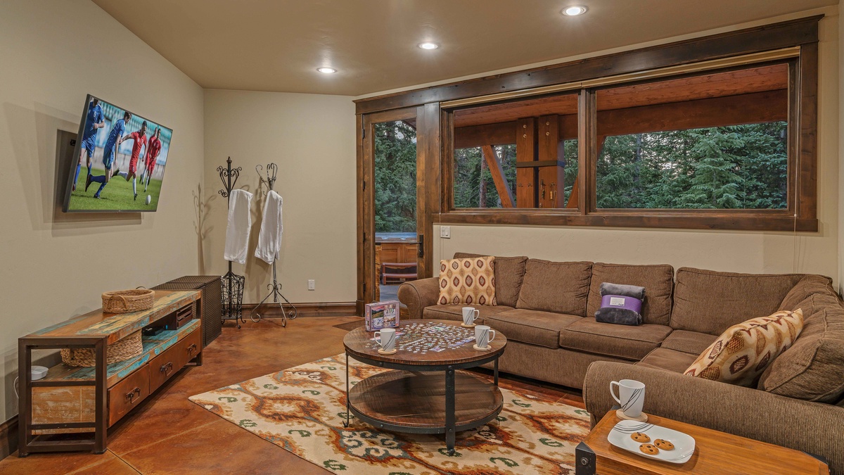 Lower level family room with TV, a queen sleeper sofa, and hot tub/patio access