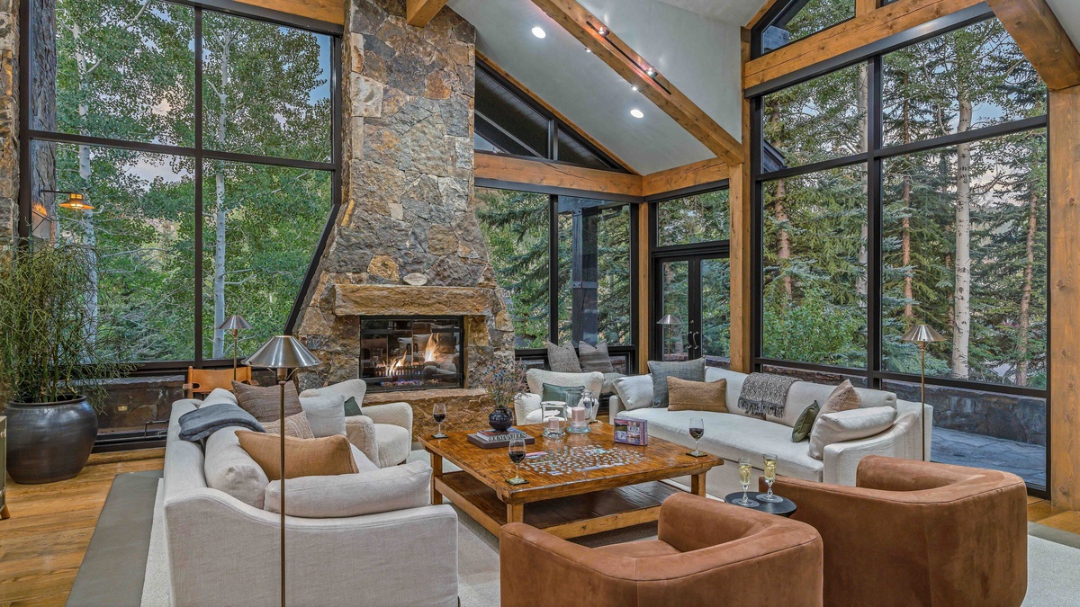 Main level great room with stone fireplace, high ceilings, and views