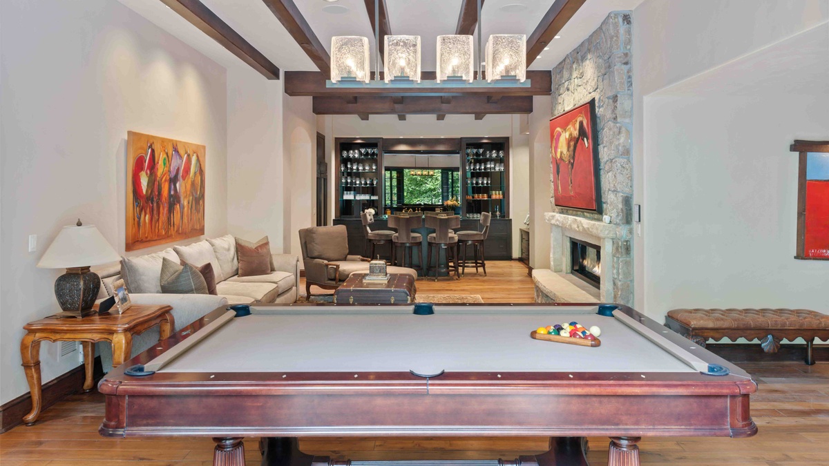 The lower level family room features a wet bar, gas fireplace, pool table and foos ball table
