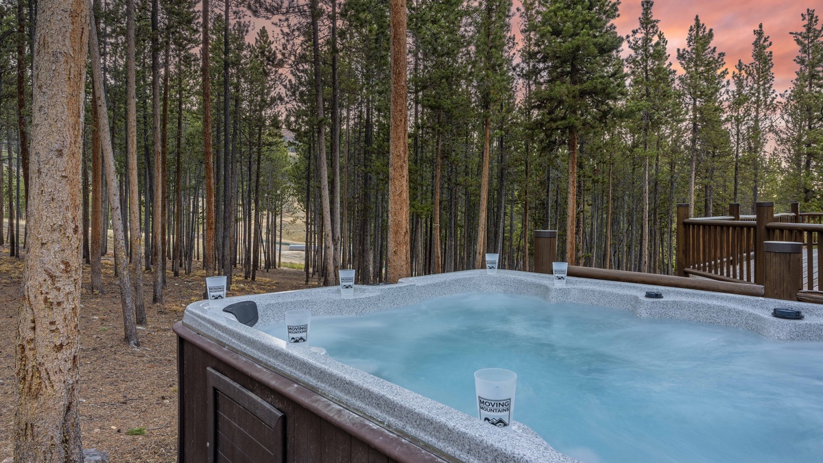 Private hot tub with a peek of the Peak 8 base area through the trees