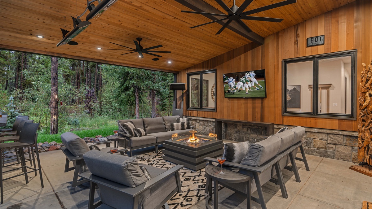 Covered back patio with plush seating, gas fireplace, and outdoor TV