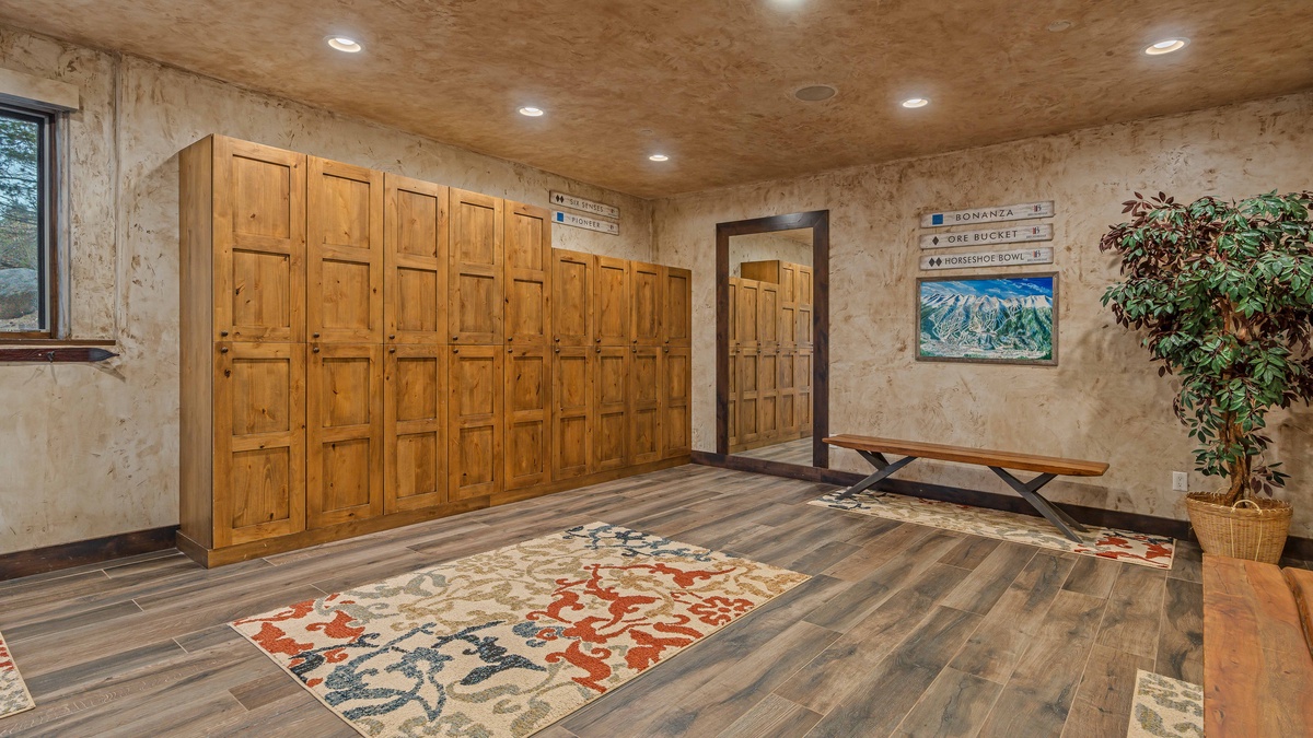 Ski storage room on main level with powder bath, separate shower, and laundry