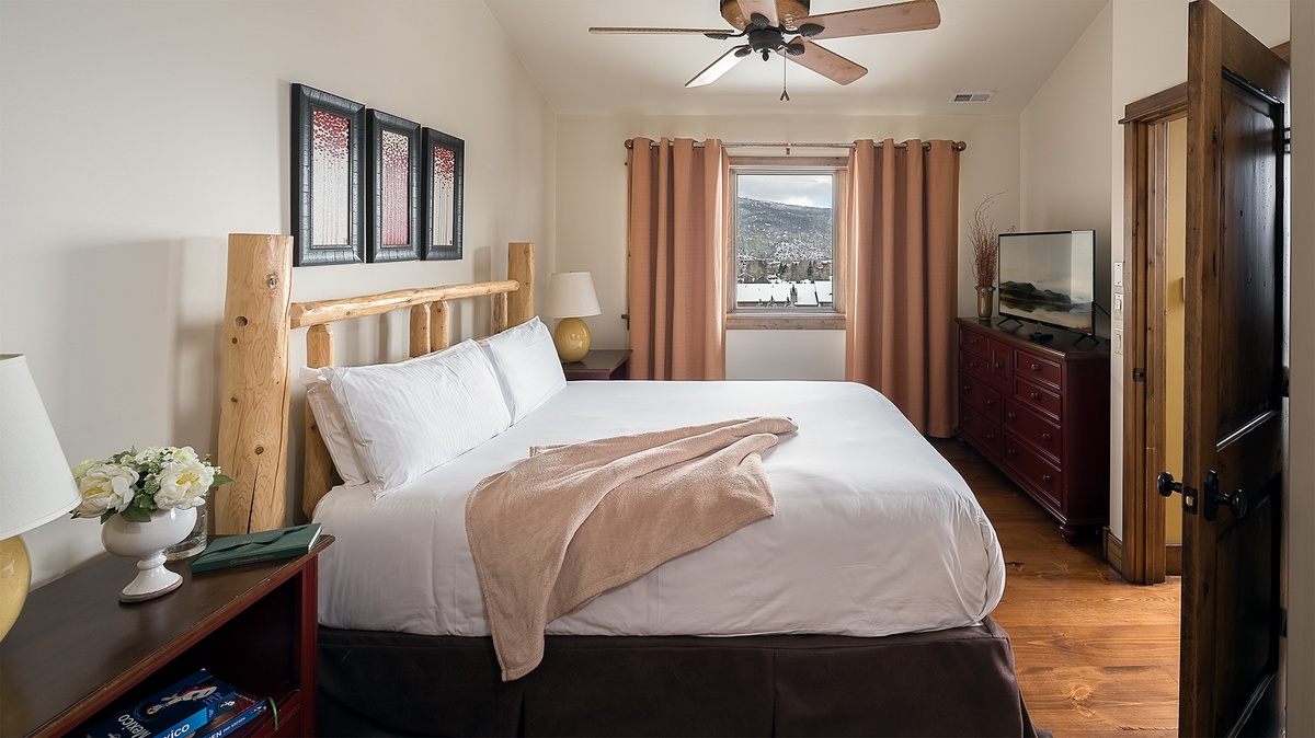 Sink into crisp linens and wake up to mountain vistas framed by your bedroom window. The rustic-chic headboard and warm wood floors create a cozy retreat after your adventures.