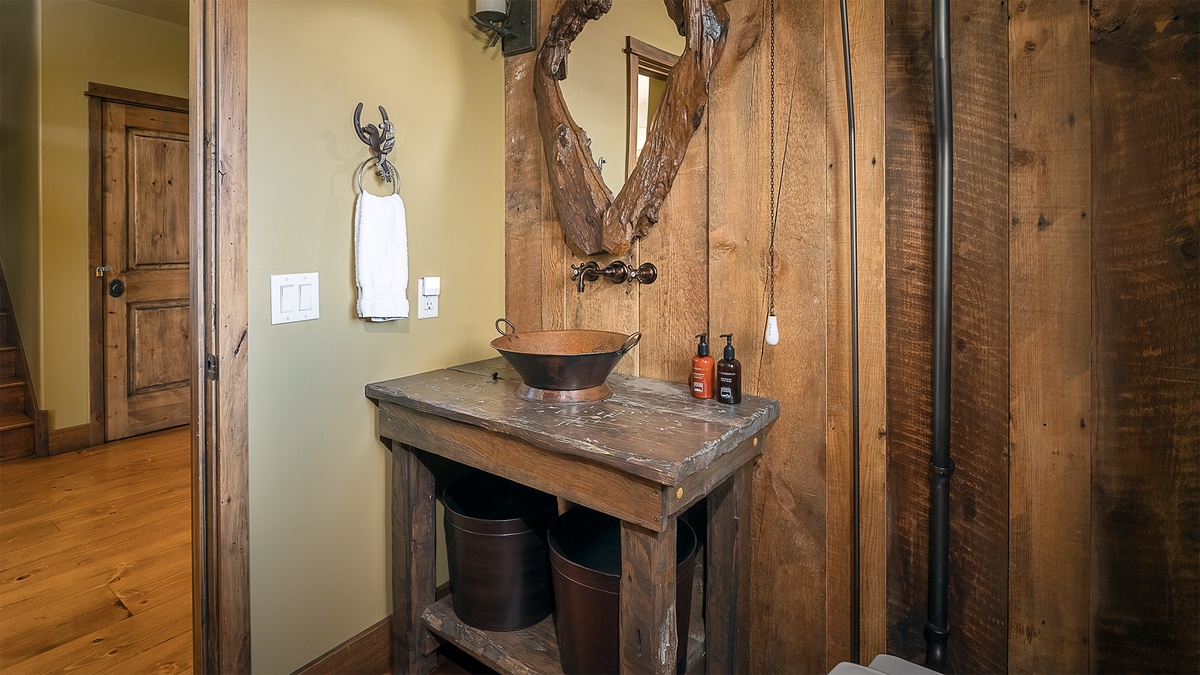 Step into a rustic retreat where handcrafted wood, antler accents, and a copper basin create a warm, inviting atmosphere perfect for unwinding after your adventures.