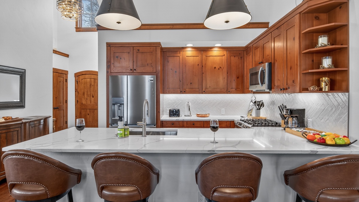 Your gourmet kitchen awaits with rich wood cabinets, marble counters, and premium appliances for memorable meal prep.