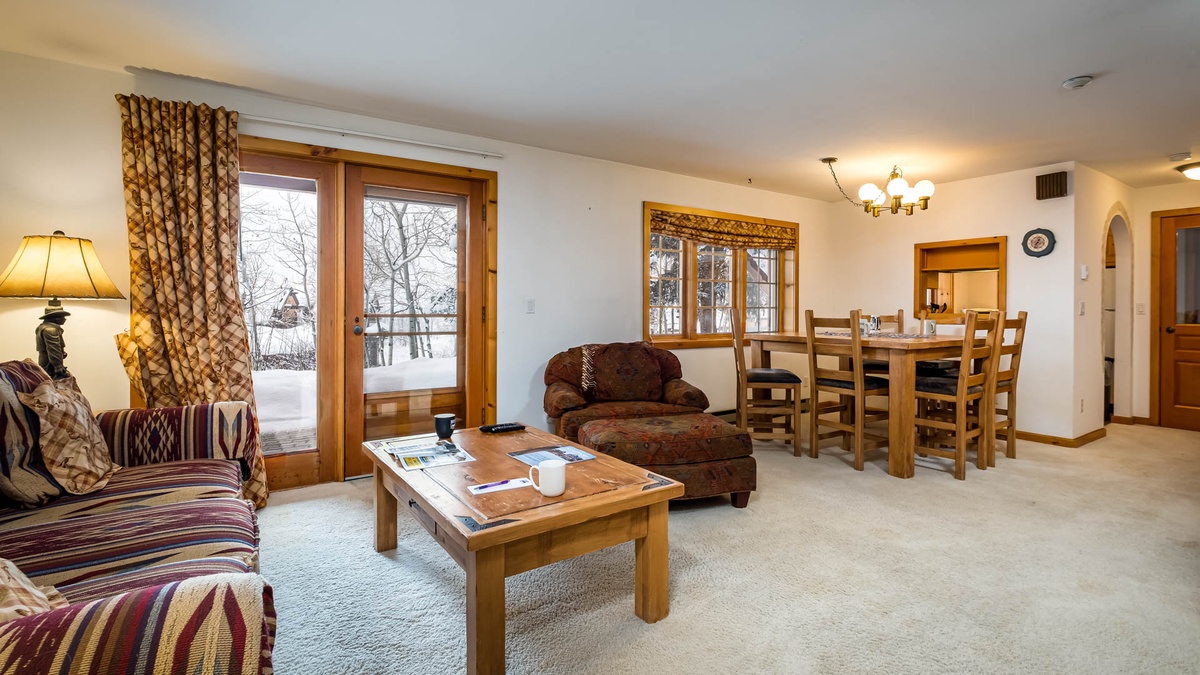 Lower level living room with TV, table, kitchen