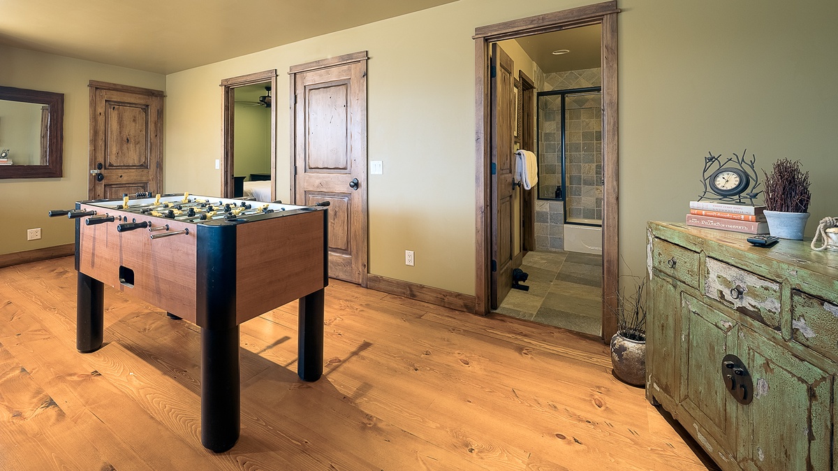 Challenge your travel companions to a friendly foosball match in this inviting game room with rustic wood details and easy access to the bathroom for refreshments and breaks.