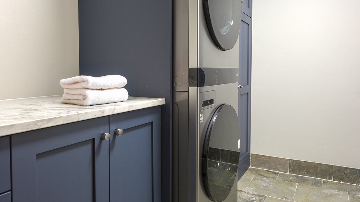 Laundry, Main Level - Stacked washer and dryer with storage cabinetry