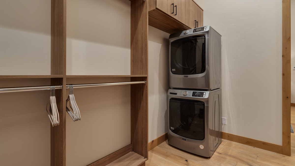 Primary bedroom walk-in closet with washer and dryer