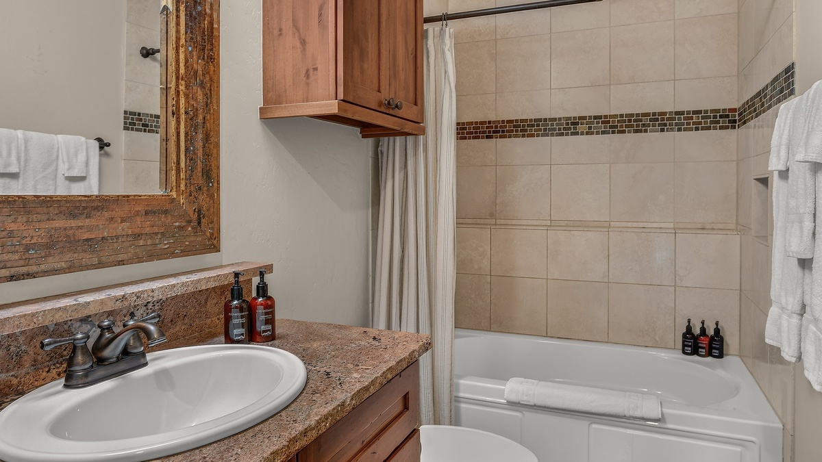 Shared Bathroom, Lower Level - Hall bathroom adjacent to Bedroom 2 with single vanity and shower/tub combo