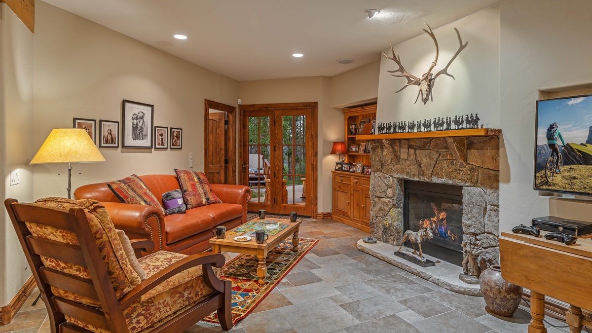 Lower level family room with TV, fireplace, and patio access