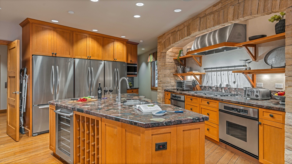 Spacious kitchen with triple fridges and large stone gas range