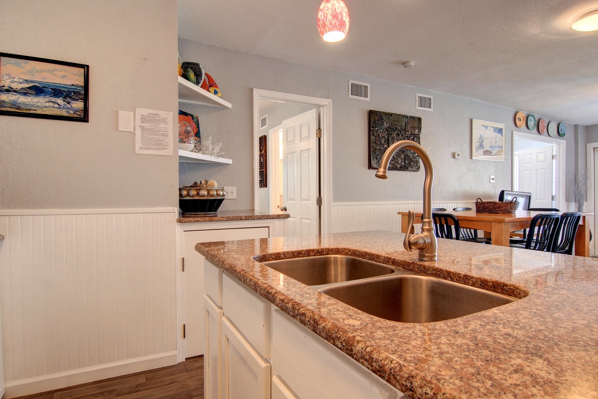 Your fully equipped kitchen features granite countertops and stainless steel double sink, perfect for preparing meals during your stay.