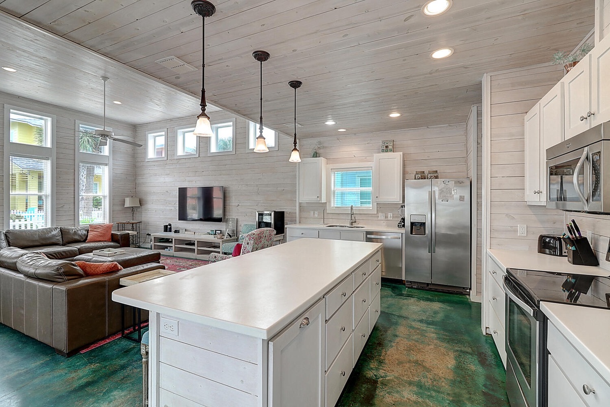Relax in your open-concept retreat with shiplap walls, sleek kitchen island, and cozy living space bathed in natural light.