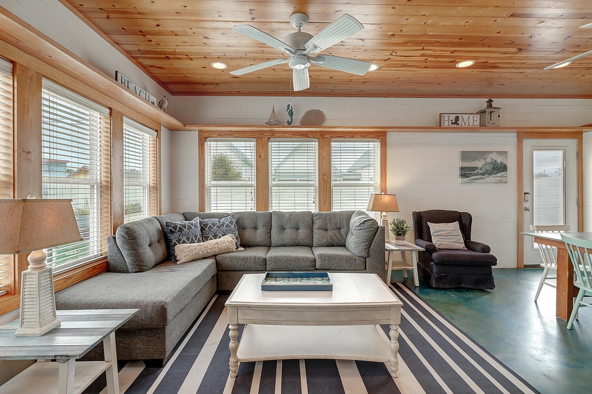 Sink into plush sectional seating where warm wood ceilings and ocean breeze from your ceiling fan create the perfect coastal retreat.