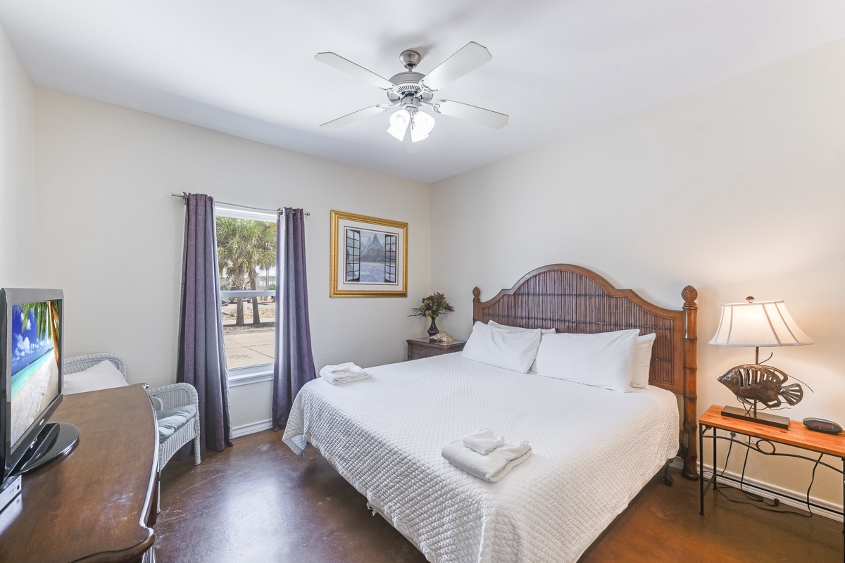 Unwind in your comfortable bedroom with tropical touches, ceiling fan, and glimpses of palm trees outside your window.