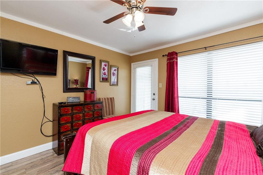 Settle into your cozy bedroom with vibrant red accents, entertainment center, and ceiling fan keeping you comfortable throughout your stay.