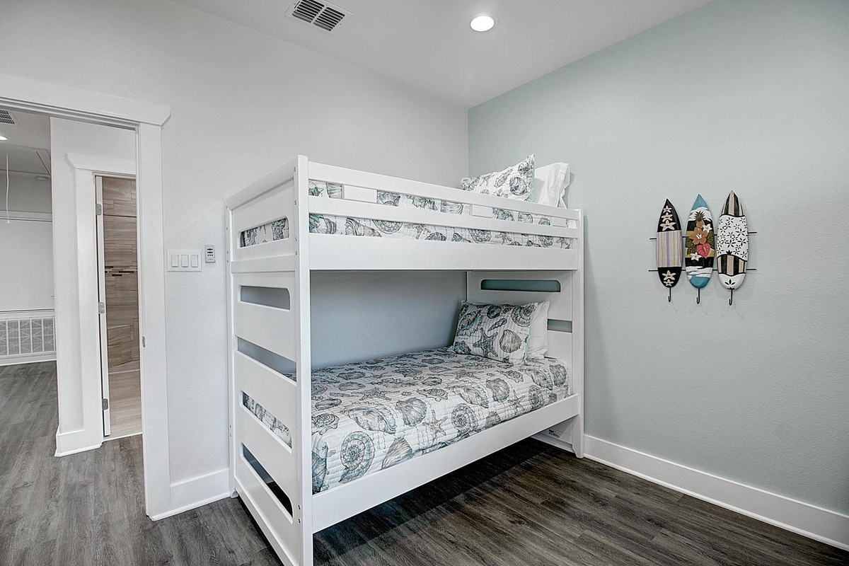 Your kids will love this cheerful bunk bed room with playful surfboard decor and plenty of space to make vacation memories together.