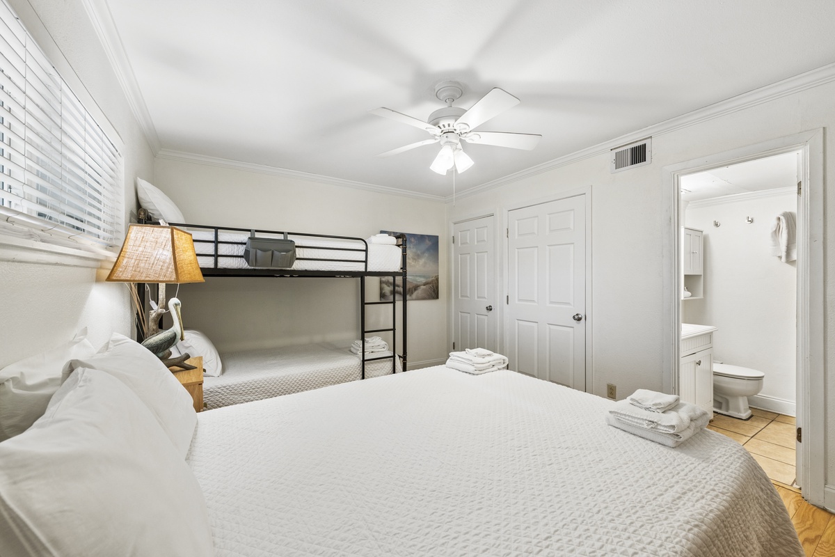 Your bright, spacious bedroom features a plush queen bed and bunk beds, perfect for families. Fresh towels await, and you'll love the convenient ensuite bathroom and ceiling fan.