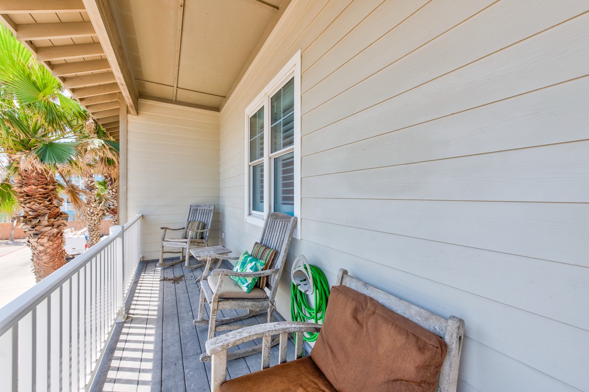 Relax on your private covered porch with comfortable seating, tropical palm views, and gentle ocean breezes.