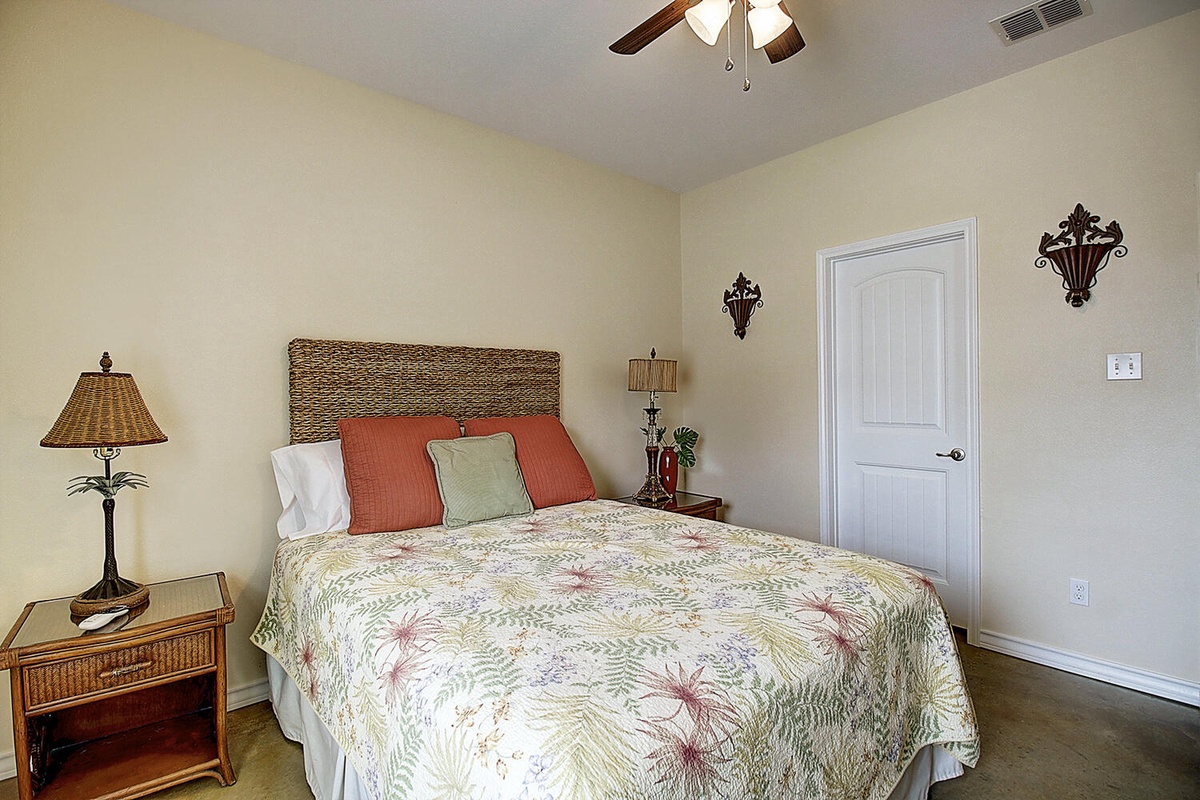Your peaceful bedroom sanctuary features tropical-inspired bedding and warm wicker accents, creating the perfect retreat for restful nights.