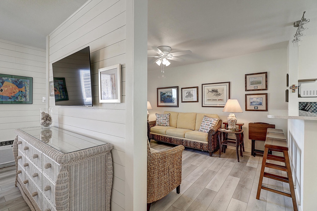 Relax in your bright living space featuring coastal charm with shiplap walls, comfortable seating, and warm nautical touches throughout.