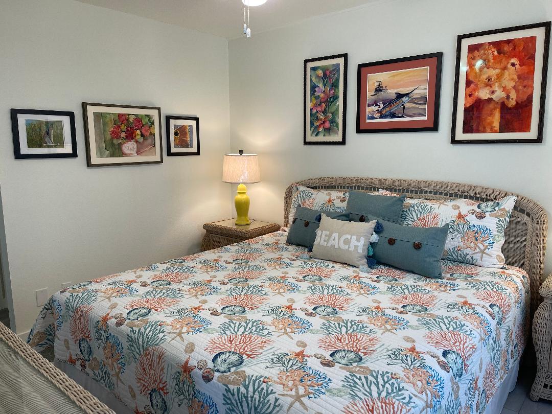 Drift off surrounded by coastal charm in this thoughtfully decorated bedroom featuring nautical-themed bedding and beach-inspired artwork.
