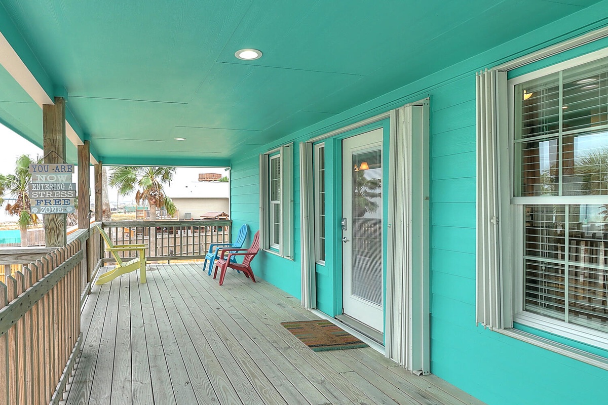 Your vibrant turquoise balcony overlooks tropical palms, with colorful chairs perfect for morning coffee or sunset cocktails.