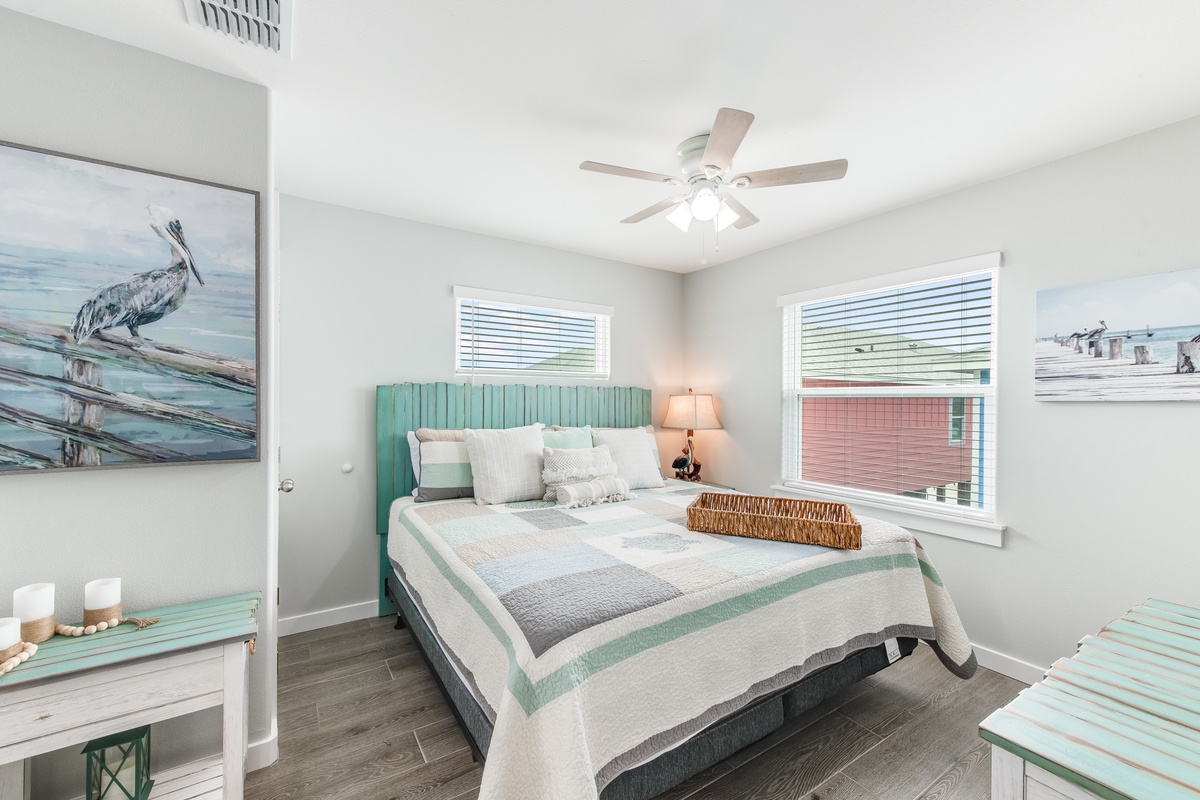 Drift into peaceful sleep in your coastal-themed bedroom, where soft seafoam hues and charming pelican artwork create a tranquil retreat.
