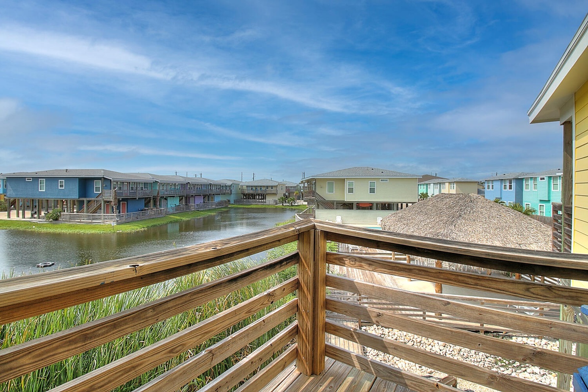 Soak up serene water views from your private deck, where colorful beach homes create a peaceful coastal community backdrop.