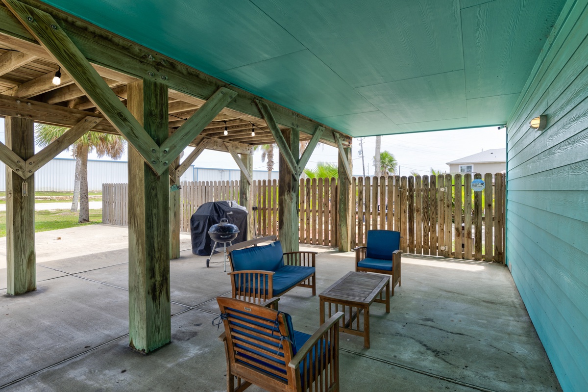 Relax in your private covered patio with comfortable seating and a grill for coastal cookouts, perfectly framed by beach views and tropical palms just steps away.