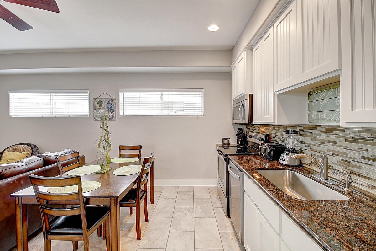 Your open-concept kitchen flows seamlessly into cozy dining and living areas, perfect for preparing meals and gathering together.