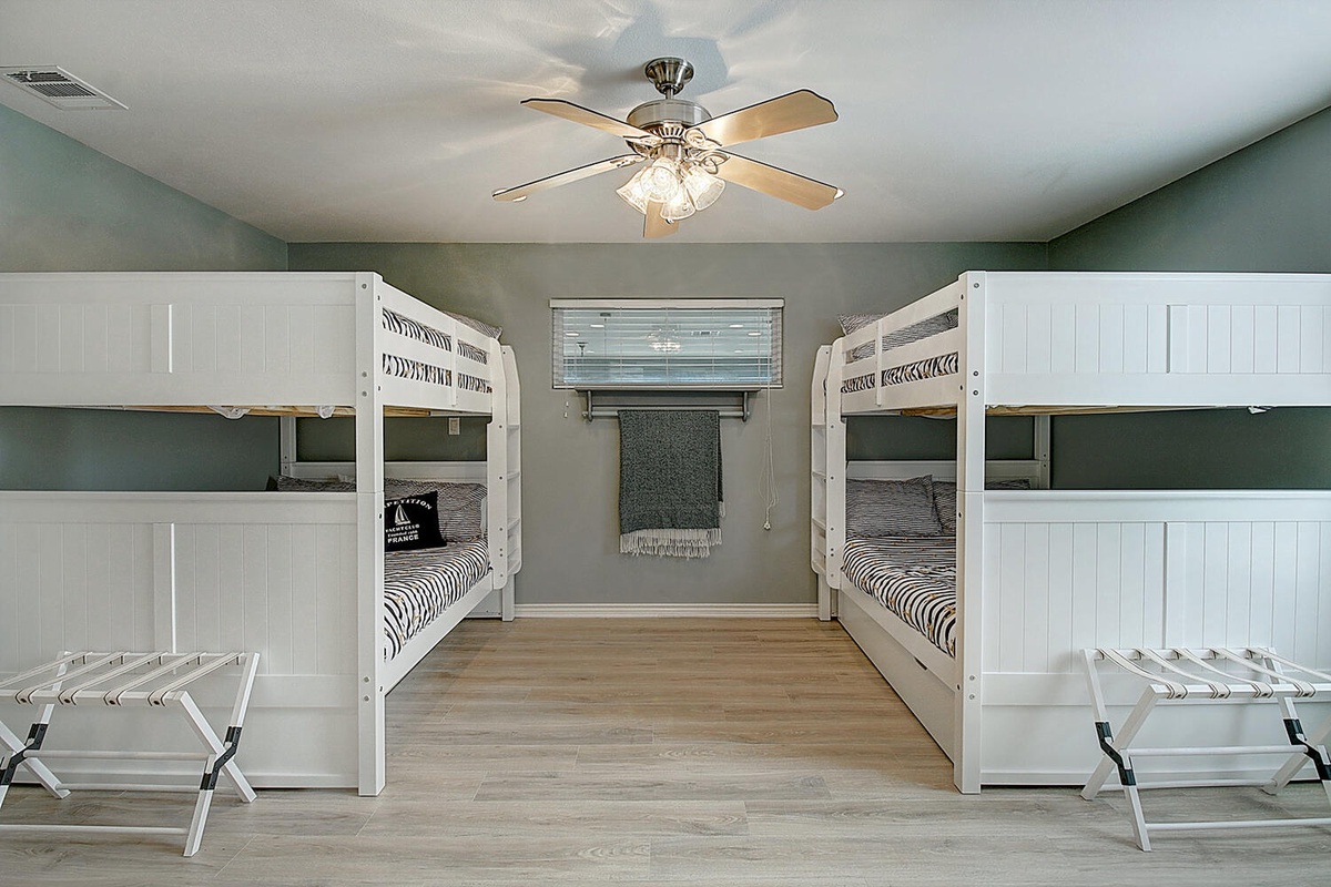 Your coastal bunk room sleeps four with crisp white beds, striped linens, and luggage racks for easy settling in.
