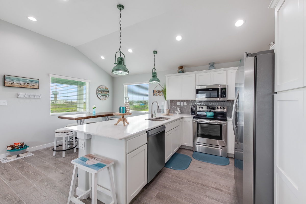 Your bright, fully-equipped kitchen awaits with modern appliances and a convenient breakfast bar for morning coffee or casual dining.