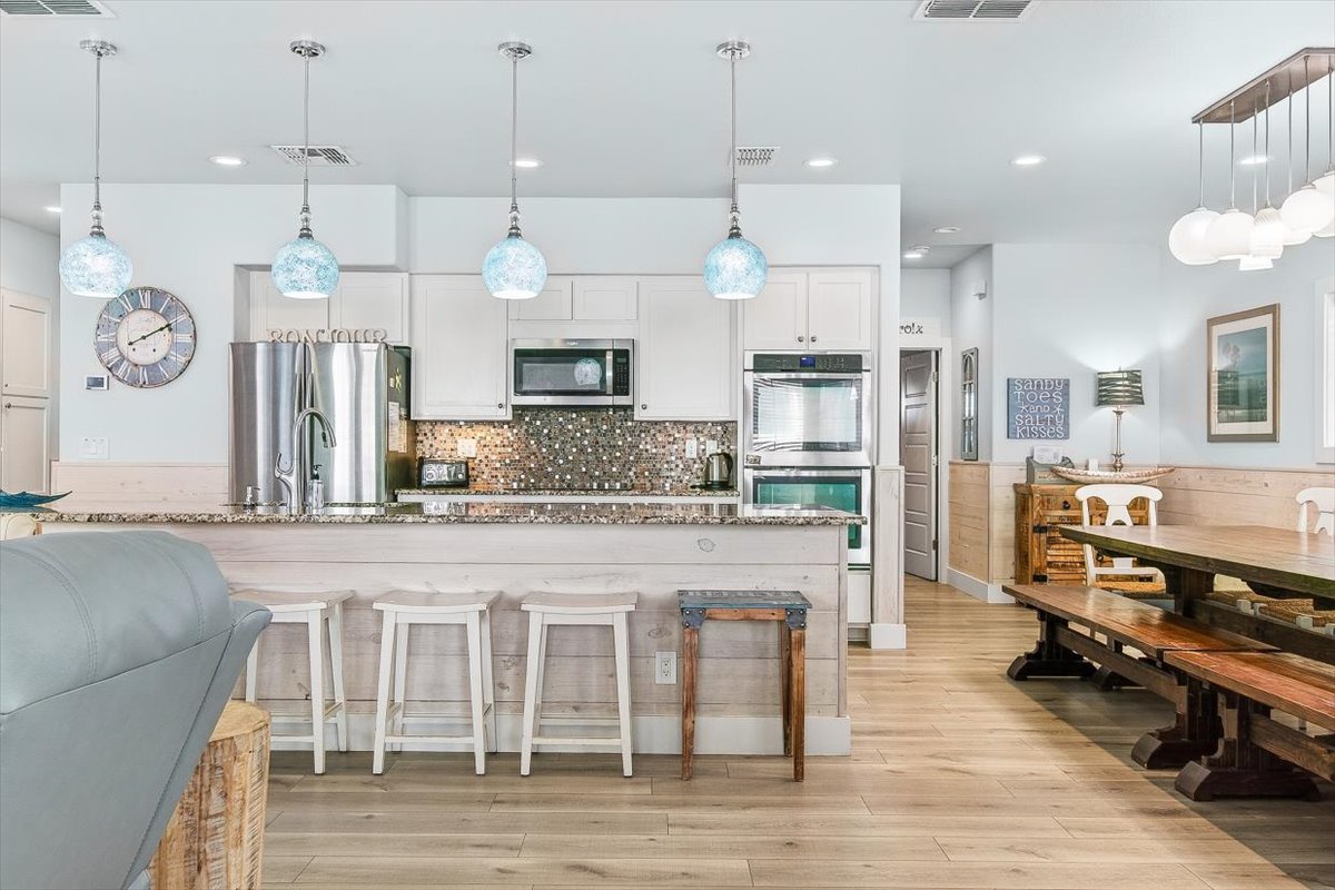 Step into your dream kitchen where pendant lights cast a warm glow over granite counters and sparkling backsplash. Gather around the island or rustic dining table for memorable meals together.