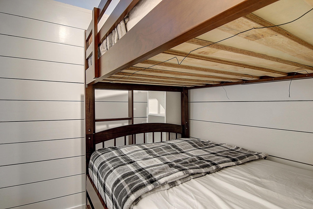 Cozy bunk bed with plaid bedding creates perfect space for restful nights in your charming retreat.