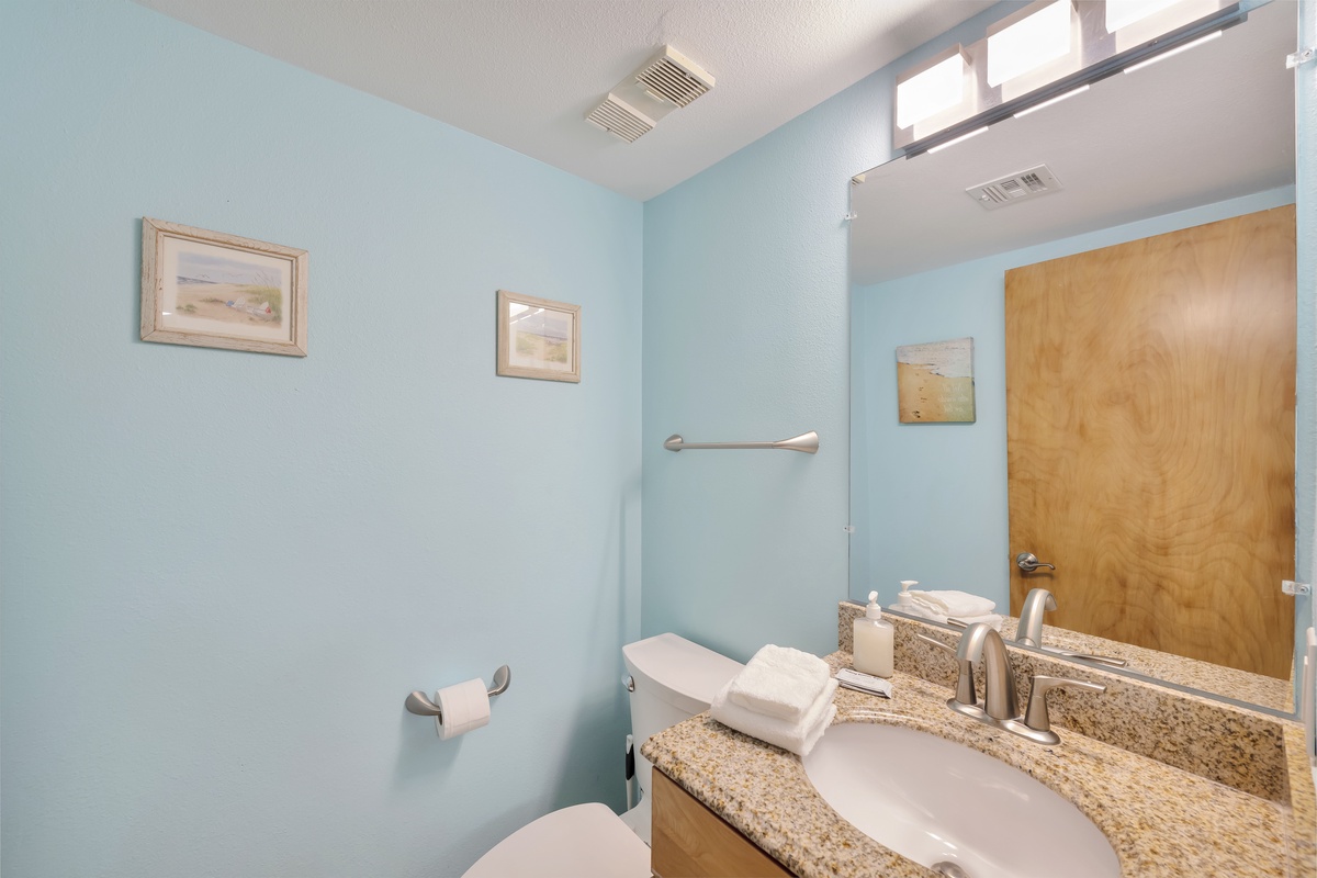 Refresh in your private bathroom featuring soothing blue walls, granite countertops, and thoughtful amenities for your comfort.