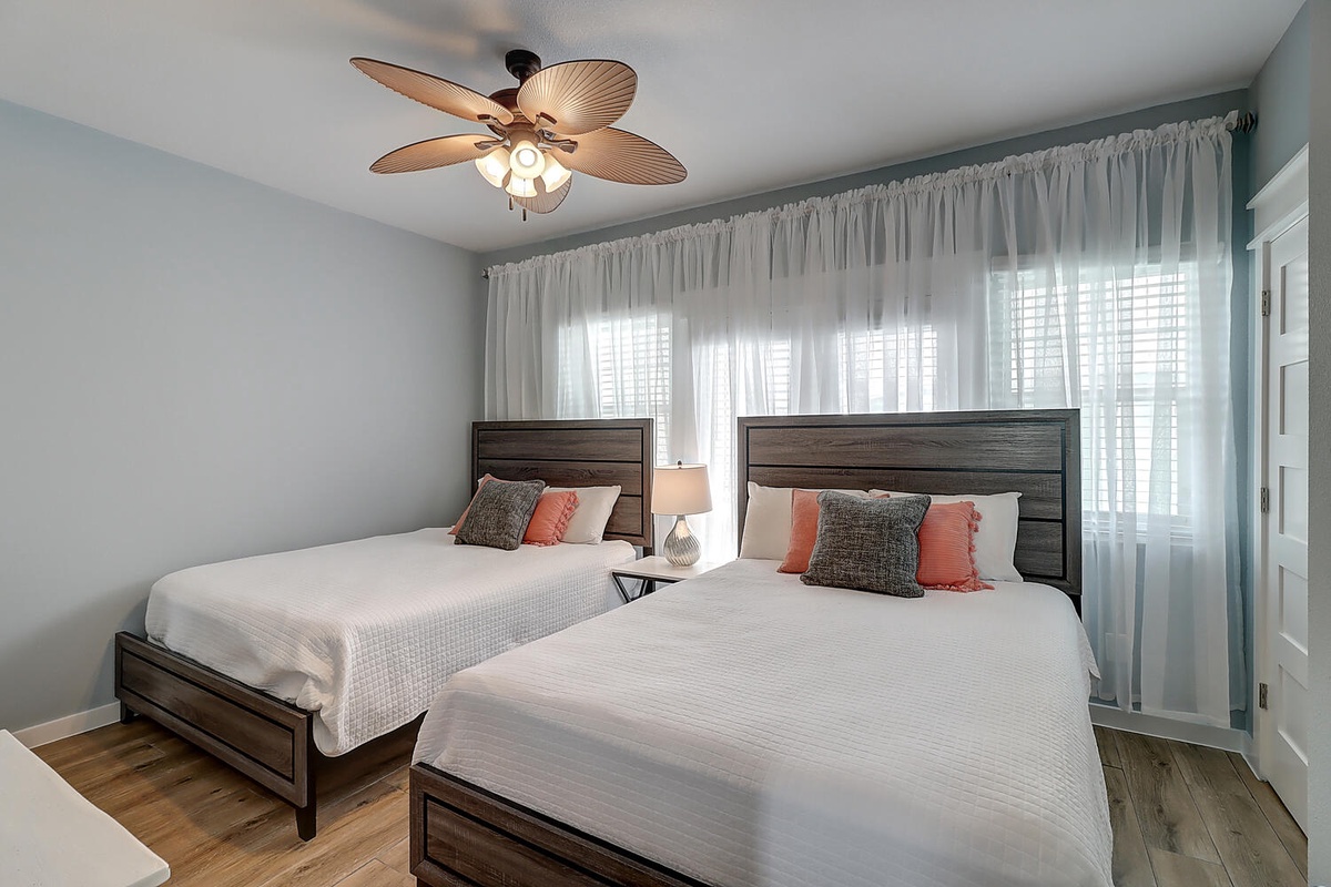 Unwind in your peaceful bedroom with twin beds, soft linens, and tropical ceiling fan keeping you cool all night long.