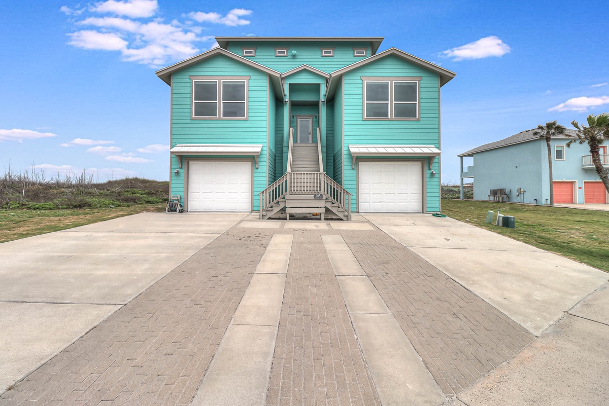 Charming turquoise beach house with spacious parking and easy access to your coastal getaway adventure.