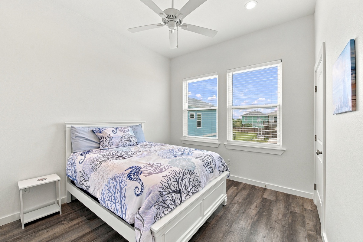 Drift off in your primary bedroom retreat, with a queen bed and ocean-inspired decor and gentle breezes from your ceiling fan invite restful nights by the shore.