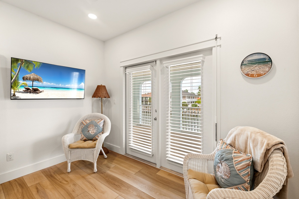 Settle into your cozy coastal retreat with soft wicker seating and bright natural light streaming through plantation-shuttered doors. Your perfect spot to unwind and soak in the relaxed beach-house vibes.