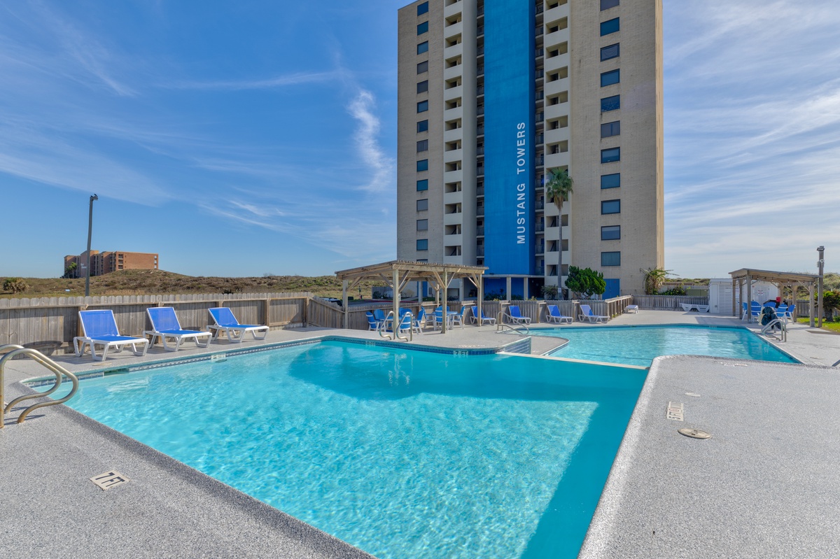 Mustang Towers offers a sparkling outdoor pool with comfortable loungers for sunny relaxation days.