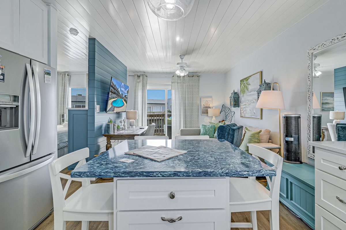 Cook in your bright coastal kitchen with gorgeous marble island, modern appliances, and charming shiplap ceiling that creates the perfect beach house atmosphere.