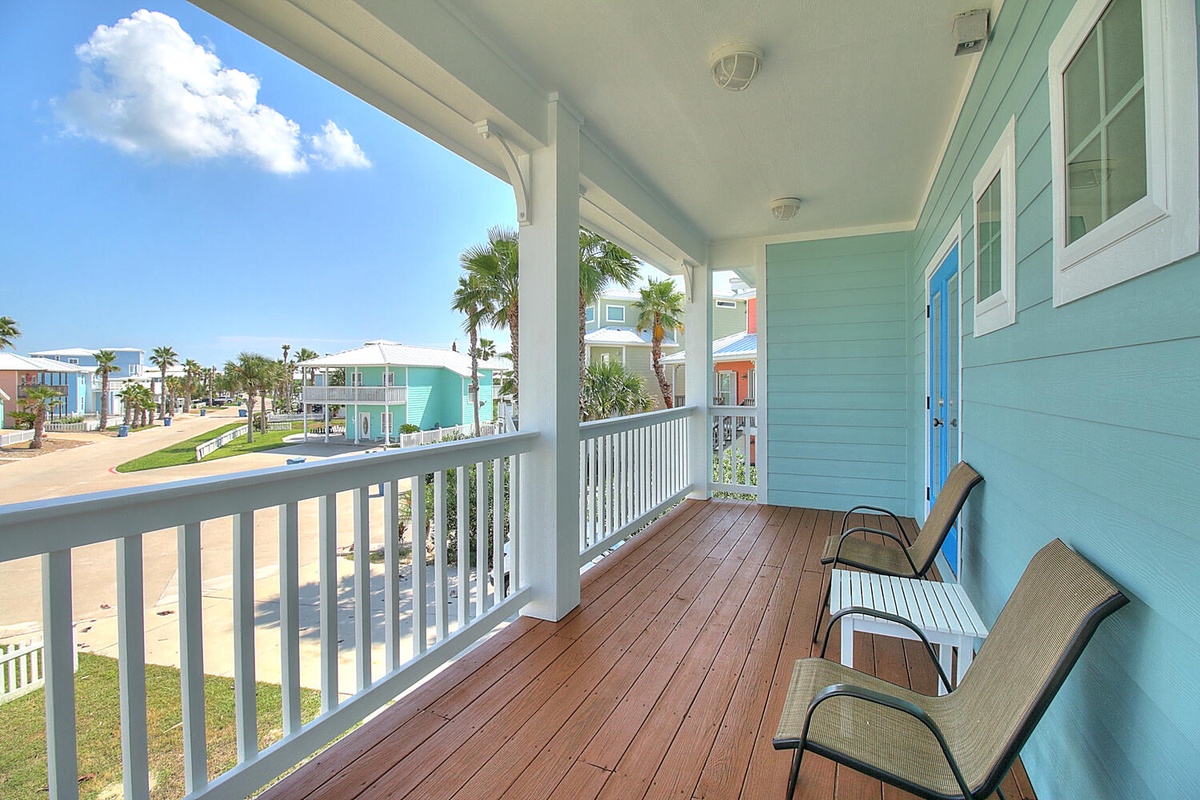 Relax on your private balcony with comfortable seating and enjoy the tropical coastal neighborhood views.